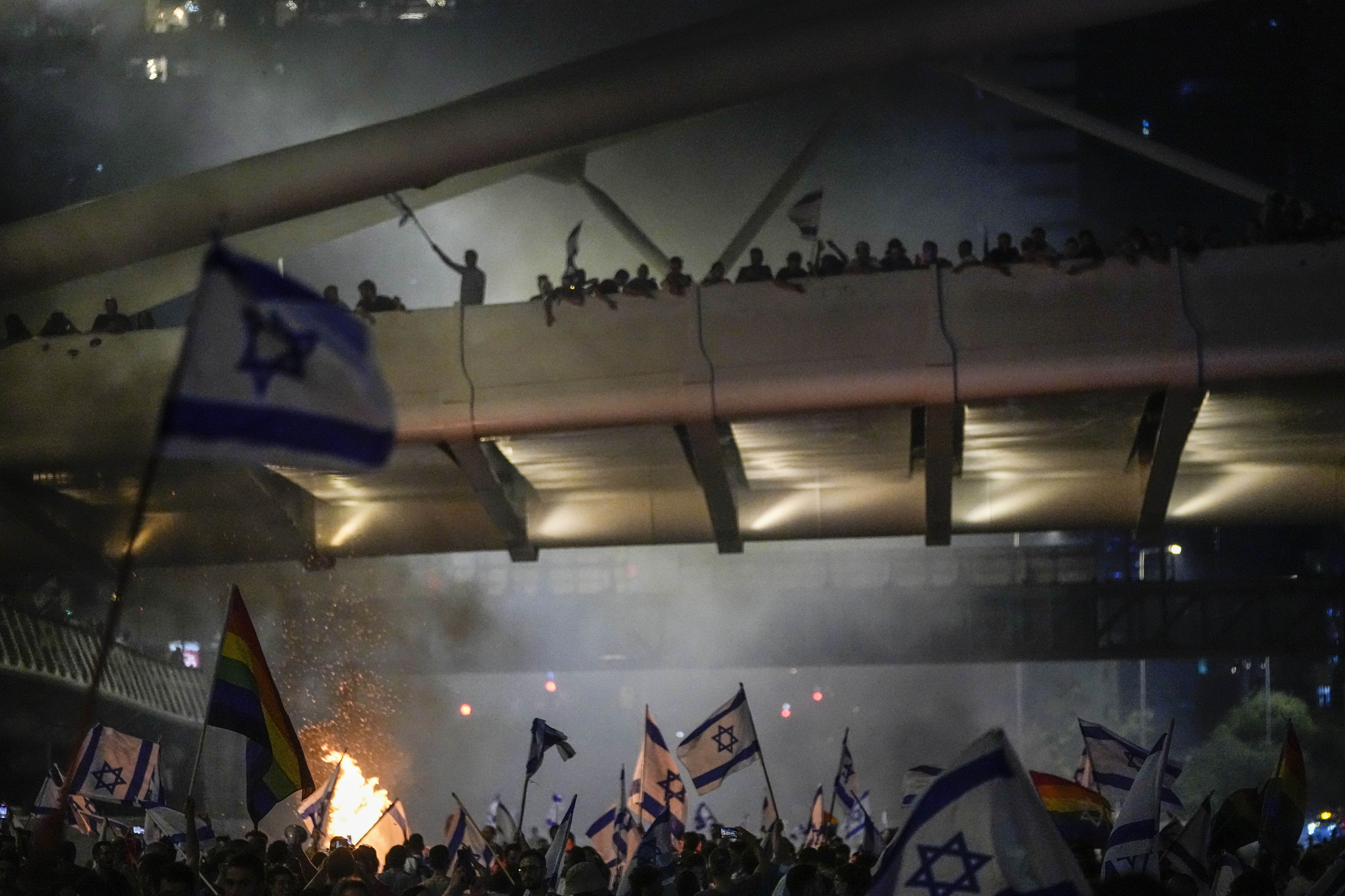 Bonfires burn as Israelis occupy the Ayalon Highway to protest against plans by Prime Minister Benjamin Netanyahu's government to overhaul the judicial system, in Tel Aviv, Thursday, July 20, 2023. (AP Photo/Ariel Schalit)