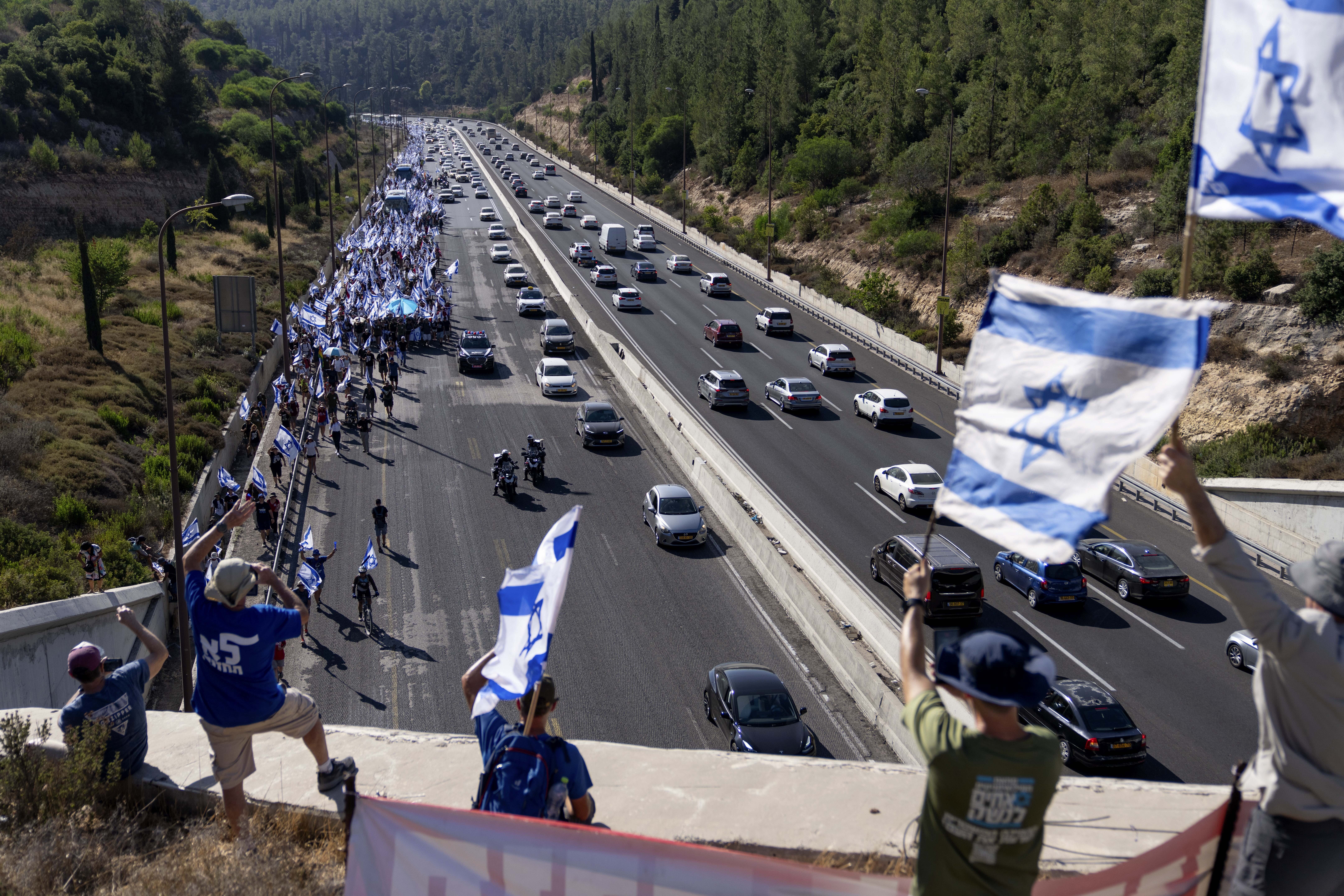 Israelis march along Highway 1 on their way to Jerusalem, near Moshav Shoresh in Israel, as part of protests against plans by Prime Minister Benjamin Netanyahu's government to overhaul the judicial system, Friday, July 21, 2023. The protest march from Tel Aviv to Jerusalem is growing as Netanyahu vows to forge ahead on the controversial overhaul. Protest organizers planned to camp overnight at Shoresh, before making their way to Israel's parliament on Saturday. (AP Photo/Ohad Zwigenberg)