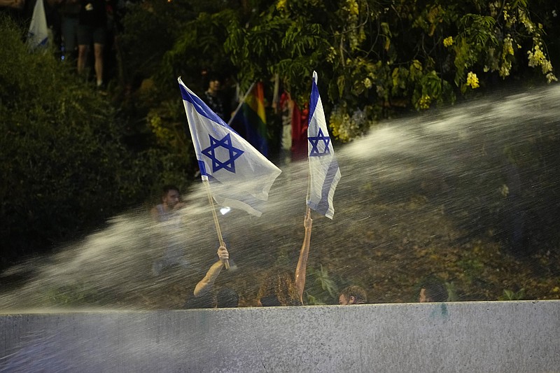 Police use a water cannon on Israelis occupying the Ayalon Highway to protest against plans by Prime Minister Benjamin Netanyahu's government to overhaul the judicial system, in Tel Aviv, Friday, July 21, 2023. (AP Photo/Ohad Zwigenberg)