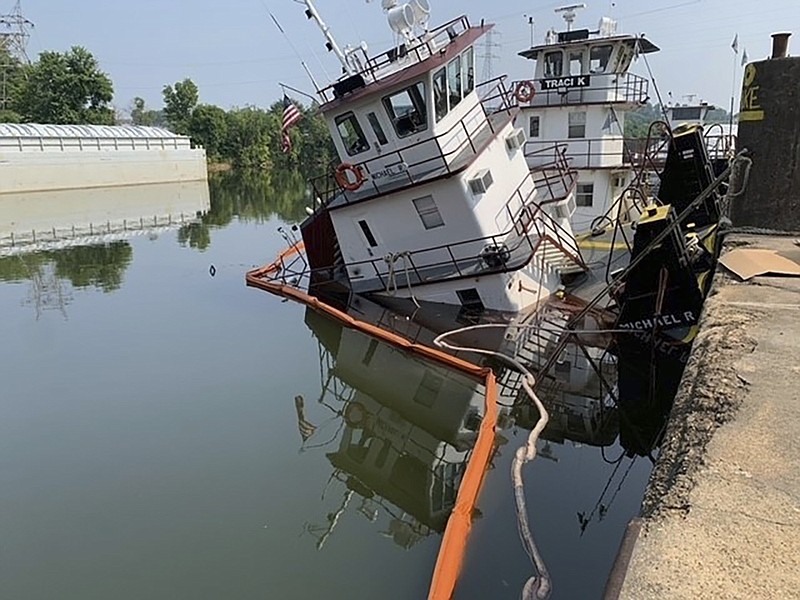 In this photo provided by the U.S. Coast Guard/Marine Safety Detachment Nashville, floating containment boom tries to limit diesel fuel spilling from a partially sunken tugboat in Florence, Ala., on Monday July 17, 2023. Local officials announced on Monday, July 24, 2023, that they were reopening a beach on the Tennessee River in a Florence park. (U.S. Coast Guard/Marine Safety Detachment Nashville via AP)