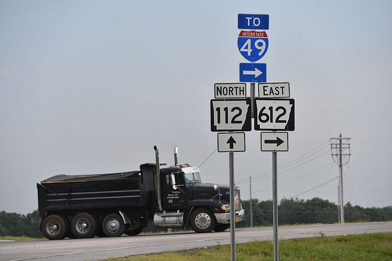 A dump truck heads east onto Arkansas 612 at Arkansas 112 north of Elm Springs in Springdale on Friday, July 28, 2023. Northwest Arkansas regional planners are pursuing $50 million in federal grants to help pay for two major transportation projects, another section of the Springdale Northern Bypass and improvements to Arkansas 112. (NWA Democrat-Gazette/Andy Shupe)