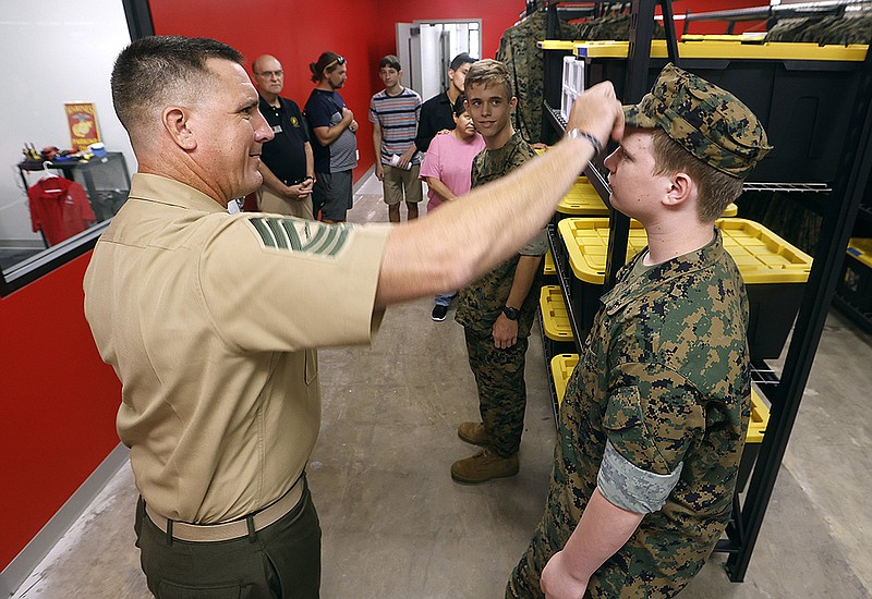 Marine JROTC instructor Master Sgt. Jeremy Masters adjusts the cover of cadet David Poe, 14, who will be a ninth grader at the Arkansas Military & First Responders Academy, on Tuesday, Aug. 1, 2023, during the school’s ribbon cutting event in Little Rock. .(Arkansas Democrat-Gazette/Thomas Metthe)