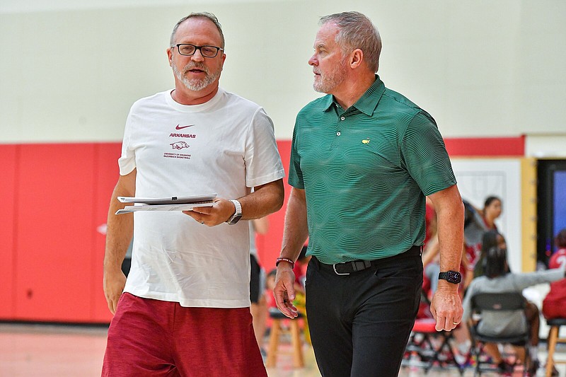 Arkansas Athletic Director Hunter Yurachek (right) speaks with women’s basketball Coach Mike Neighbors on Friday in Fayetteville. Yurachek said he would be in favor of implementing a third-party central reporting model for the NIL process and added that it would cut down on tampering and the falsity of some reported NIL deals.
(NWA Democrat-Gazette/Hank Layton)