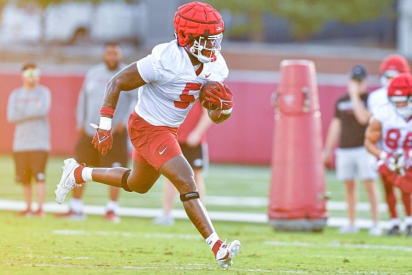 Arkansas running back Raheim Sanders (5) carries the ball, Friday, Aug. 4, 2023, during the Razorbacks’ first practice of fall camp at the Fred W. Smith Football Center in Fayetteville.