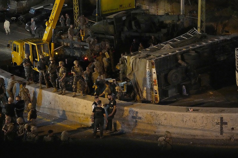 Lebanese soldiers stand guard next to an overturned truck, Wednesday in the Christian town of Kahaleh, Lebanon.
(AP/Hussein Malla)