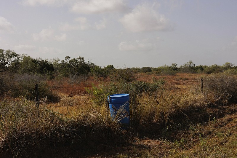 A water station for immigrants containing sealed jugs of fresh water sits along a fence line last month near a roadway in rural Jim Hogg County, Texas.
(AP/Michael Gonzalez)