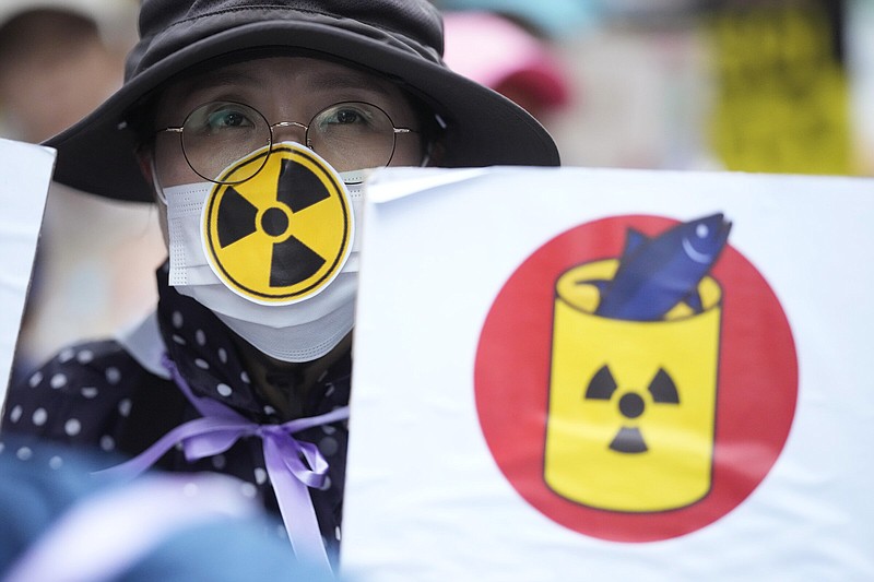 A person holds a poster to protest Japan’s plan to release treated radioactive water from the wrecked Fukushima nuclear power plant during a march Saturday along a street in Seoul, South Korea.
(AP/Lee Jin-man)