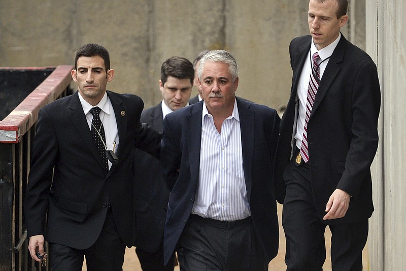 FILE — Former Suffolk County Police Chief James Burke, second from right, is escorted to a vehicle by FBI personnel outside an FBI office, in Melville, N.Y., Dec. 9, 2015. Burke, 58, who served federal prison time for beating a suspect, was arrested Tuesday, Aug. 22, 2023, for allegedly soliciting sex and exposing himself at a public park in Farmingdale, on New York's Long Island. (Steve Pfost/Newsday via AP, File)