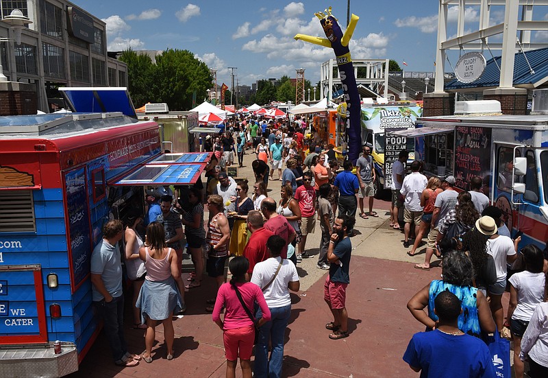 Staff File Photo / Customers line up at food trucks parked along Reggie White Boulevard during the Street Food Festival at the Chattanooga Market on Sunday, June 14,  2015.  Chattanooga Market will host a Fall Food Truck Rally from 11 a.m.-4 p.m. Sunday at First Horizon Pavilion, 1801 Reggie White Blvd. In addition to the market’s variety of vendors and live music performances, attendees will have the opportunity to eat at a wide array of local food trucks. Admission is free.