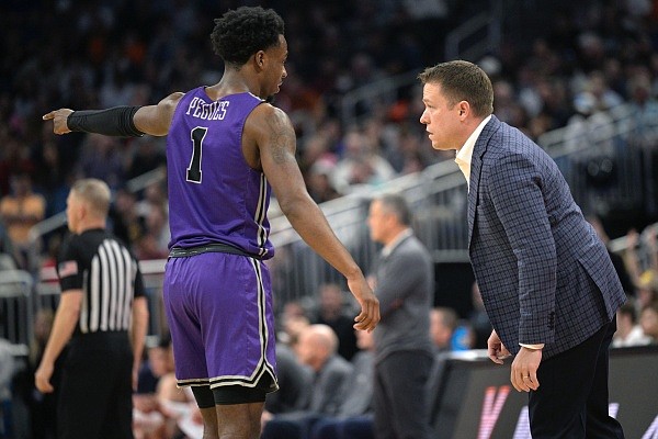 Furman guard JP Pegues (1) talks with head coach Bob Richey, right, during the second half of a first-round college basketball game against Virginia in the NCAA Tournament, Thursday, March 16, 2023, in Orlando, Fla. (AP Photo/Phelan M. Ebenhack)