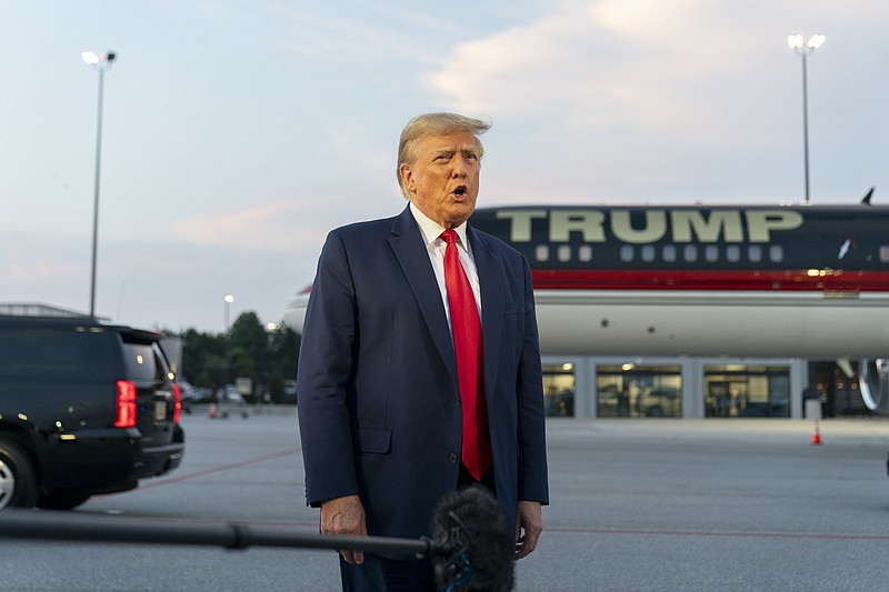 FILE - Former President Donald Trump speaks with reporters before departure from Hartsfield-Jackson Atlanta International Airport, Thursday, Aug. 24, 2023, in Atlanta. Trump has pleaded not guilty and waived arraignment in the case accusing him and others of illegally trying to overturn the results of the 2020 election in Georgia. (AP Photo/Alex Brandon, File)