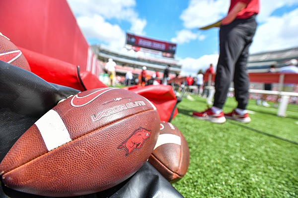Footballs rest on the sideline, Saturday, April 15, 2023, during the Red-White Spring Football Showcase at Donald W. Reynolds Razorback Stadium in Fayetteville.