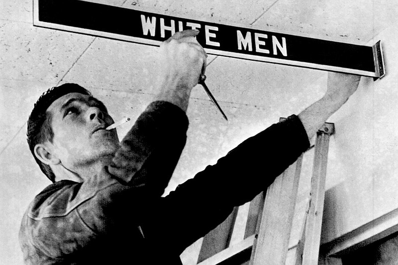 A workman removes a restroom sign at Montgomery (Ala.) Municipal Airport in this Jan. 5, 1962 file photo. The sign was being removed in compliance with a federal court order banning segregation. However, city officials at the time said that the airport's toilets, water fountains and restaurant would be closed if federal officials made a concerted attempt to integrate the facility. "Disenfranchisement and Jim Crow Laws," which addresses segregated water fountains and restrooms, is part of the national College Board's Advanced Placement African American studies course, specifically topic 3.5 in unit 3, "The Practice of Freedom." (AP/File)