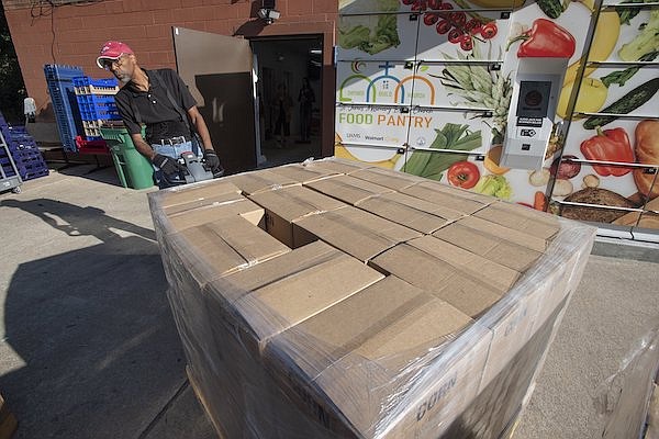 Ron Keown of Lowell pulls pallets of canned food into the St. James Missionary Baptist Church food pantry Friday, Sept. 15, 2023. Ahead of Saturday’s football game between BYU and Arkansas, the BYU Alumni’s Cougs Care program and its sponsoring institution, The Church of Jesus Christ of Latter-Day Saints, delivered a truckload of food to the pantry that included 24 pallets containing 40,000 pounds of food.