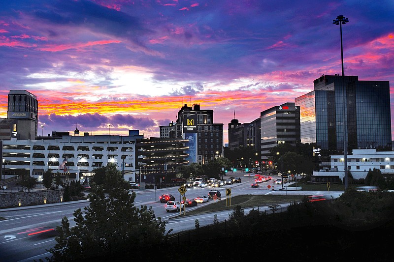 Staff Photo by Robin Rudd / Dawn breaks over the Chattanooga skyline Sept. 6 as traffic moves on M.L. King Boulevard, through the West Village.