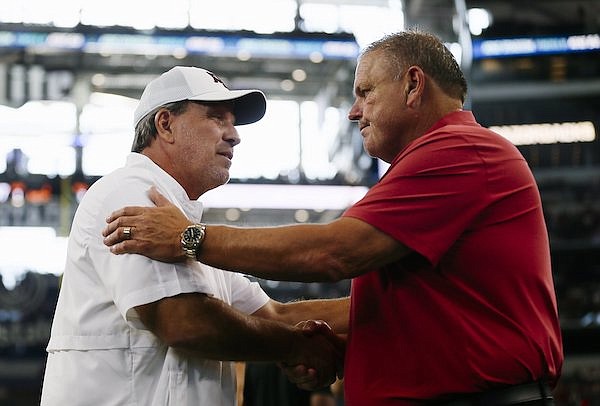 Arkansas coach Sam Pittman (right) and Texas A&M coach Jimbo Fisher shake hands prior to a game Saturday, Sept. 25, 2022, in Arlington, Texas.