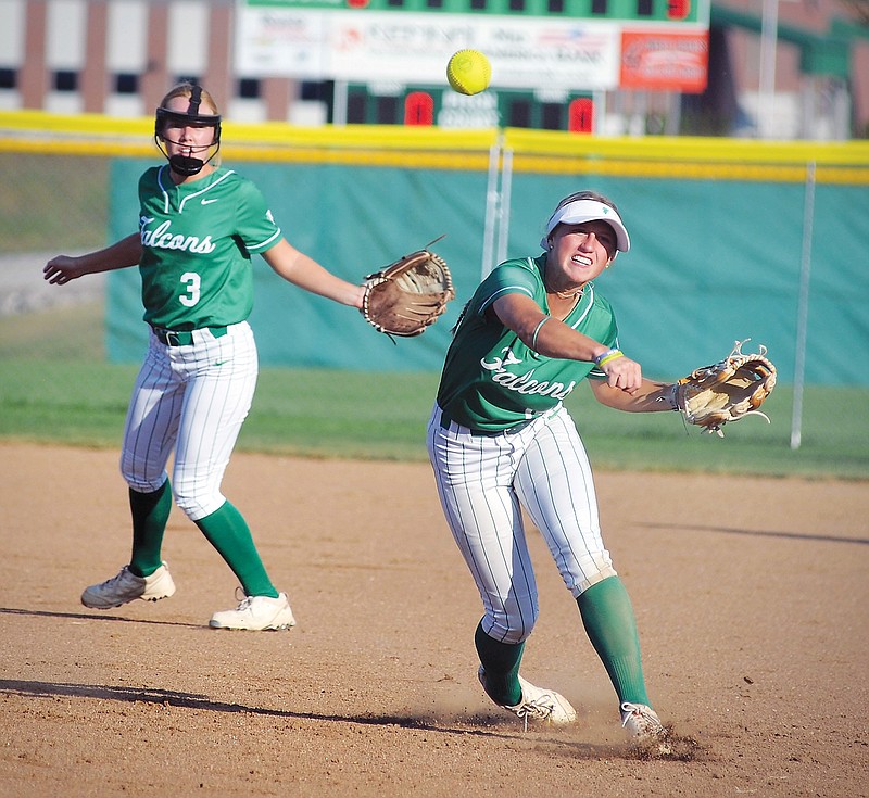 As second baseman Bria Boessen watches, Blair Oaks shortstop Baley Rackers throws the ball to first base during Monday’s game against Fulton at the Falcon Athletic Complex in Wardsville. (Shaun Zimmerman/News Tribune)