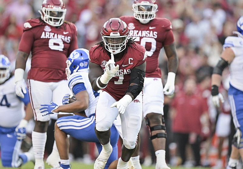 University of Arkansas defensive end Trajan Jeffcoat, shown celebrating after tackling BYU quarterback Kedon Slovis last Saturday in Fayetteville, knows the Razorbacks will have a tough task trying to contain LSU quarterback Jayden Daniels. “I feel like he’s a very quick, very athletic, very, very good quarterback,” Jeffcoat said. “He’s very fast, very shifty. He can throw. He can do it all.”
(NWA Democrat-Gazette/Charlie Kaijo)