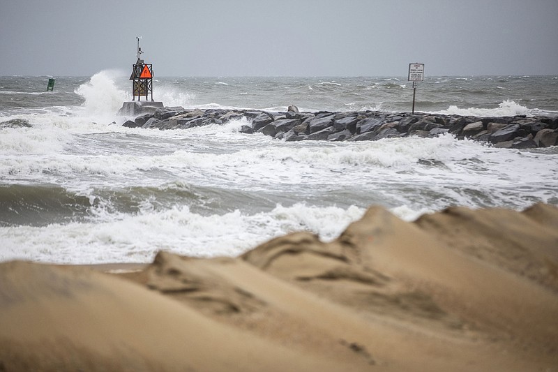 Waves break along the jetty at Rudee Inlet in Virginia Beach, Va., on Friday, Sept. 22, 2023 as Tropical Storm Ophelia approaches the area. (Kendall Warner/The Virginian-Pilot via AP)