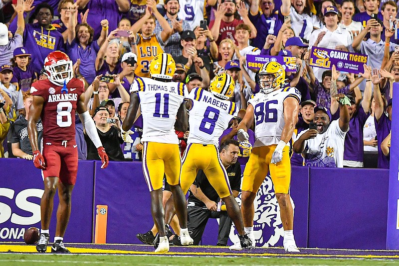 LSU wide receiver Malik Nabers (8) celebrates with teammates Brian Thomas Jr. (11) and Mason Taylor (86) near Arkansas defensive back Jayden Johnson (8) after Cabers scored a touchdown reception, Saturday, Sept. 23, 2023, during the third quarter of the Razorbacks’ 34-31 loss to the Tigers at Tiger Stadium in Baton Rouge, La.