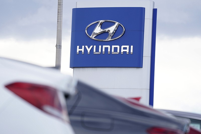 FILE - The Hyundai company logo hangs over a long row of cars at a car dealership in Centennial, Colo., Sunday, Dec. 20, 2020.