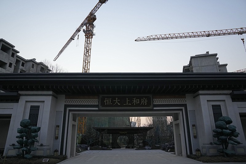 Construction cranes tower over the entrance to the Evergrande Shanghefu residential complex under construction in Beijing in 2022.
(AP)