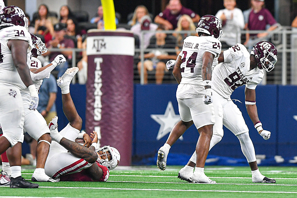 Texas A&M defensive lineman Malick Sylla (92) and linebacker Chris Russell Jr. (24) celebrate after Sylla sacked Arkansas quarterback KJ Jefferson (1), Saturday, Sept. 30, 2023, during the fourth quarter of the Aggies’ 34-22 win over the Razorbacks in the Southwest Classic at AT&T Stadium in Arlington, Texas.