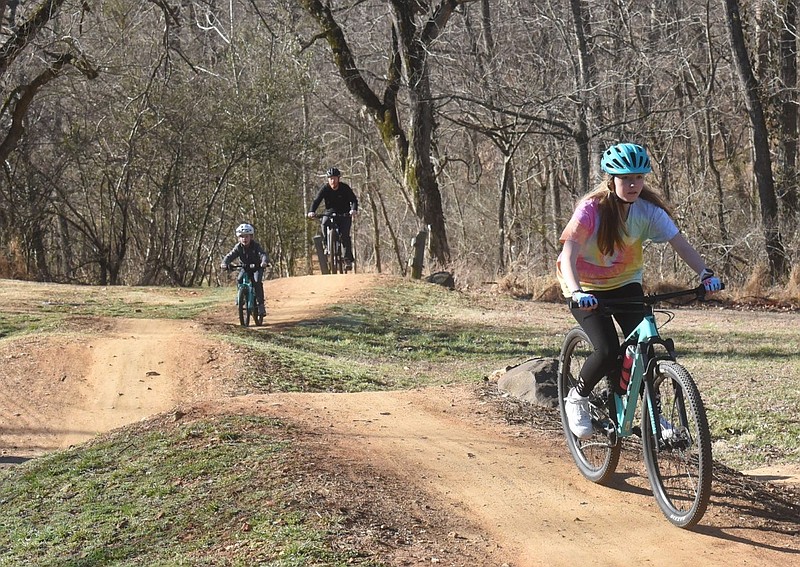Bikers north of Crystal Bridges Museum of American Art in Bentonville take a dirt trail in this March 15, 2022 file photo. (NWA Democrat-Gazette/Flip Putthoff)