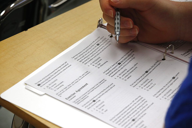 A student looks at questions during a standardized college test preparation class at Holton Arms School in Bethesda, Md., in this Jan. 17, 2016 file photo. The SAT exam moved to a digital format in 2022, while the ACT exam still gives students the option of either pencil and paper, or digital. (AP/Alex Brandon)