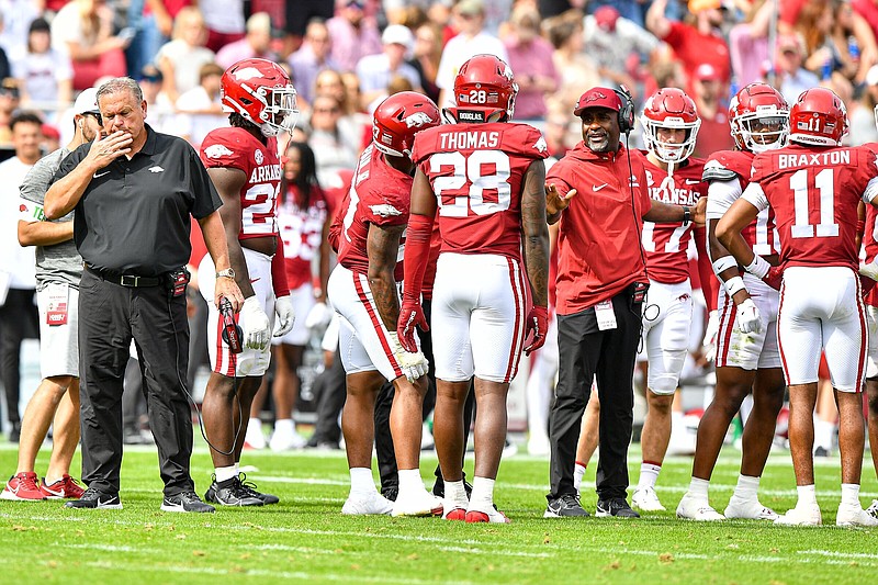 Arkansas head coach Sam Pittman (left) walks near a defensive huddle during a replay review, Saturday, Oct. 21, 2023, during the fourth quarter of the Razorbacks’ 7-3 loss to the Mississippi State Bulldogs at Donald W. Reynolds Razorback Stadium in Fayetteville. Visit nwaonline.com/photo for today's photo gallery..(NWA Democrat-Gazette/Hank Layton)