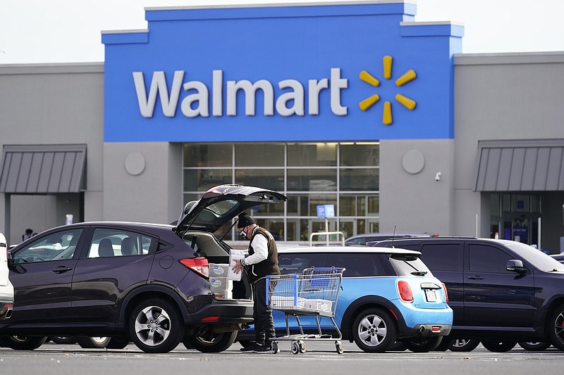FILE - A customer loads a car after shopping at a Walmart in Philadelphia, Nov. 17, 2021. Walmart, the nation's largest private employer, is expanding nationwide its health care coverage next month for employees who want to enlist the services of a doula, a person trained to assist women during pregnancies. (AP Photo/Matt Rourke, file)