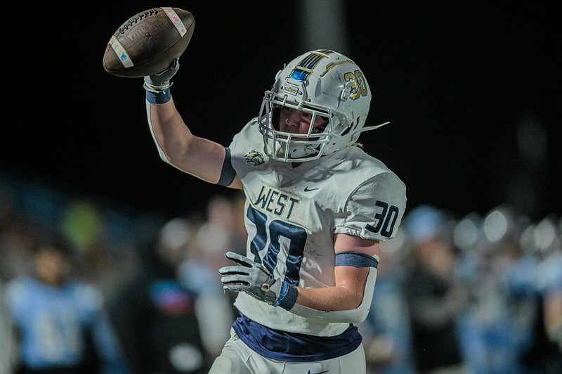 Bentonville West running back Cole Edmondson holds up the ball in celebrate after scoring a touchdown in the fourth quarter Friday night against Fort Smith Southside at Jim Rowland Stadium in Fort Smith. The Wolverines defeated the Mavericks 24-21 and will face Bentonville next week in the teams’ regular-season finale.
(NWA Democrat-Gazette/Caleb Grieger)