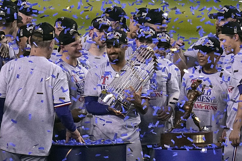 Texas Rangers' Marcus Semien holds the trophy as the Texas Rangers celebrate after winning Game 5 of the baseball World Series against the Arizona Diamondbacks Wednesday, Nov. 1, 2023, in Phoenix. The Rangers won 5-0 to win the series 4-1. (AP Photo/Gregory Bull)