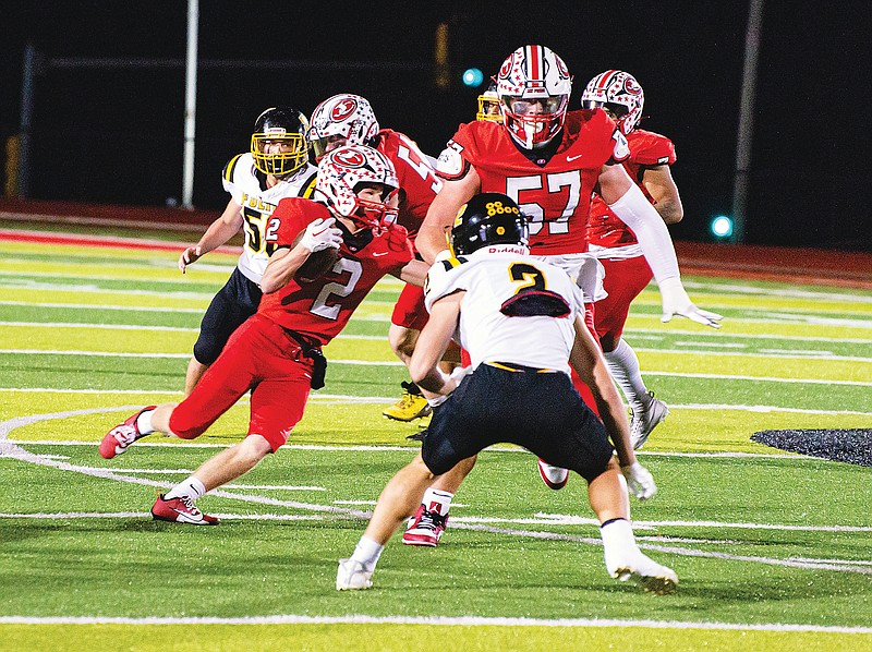 Jefferson City lineman Brody Smith (57) closes in on a block on Fulton’s Marcus Garrett while teammate Zach Barnes runs with the ball during last Friday night’s game at Adkins Stadium. (Ken Barnes/News Tribune)