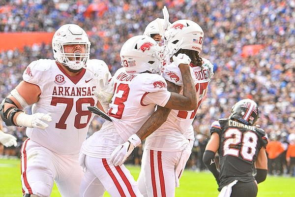 Arkansas receiver Tyrone Broden (17) is mobbed by teammates after catching the game-winning touchdown in overtime of the Razorbacks' 39-36 victory at Florida on Saturday, Nov. 4, 2023, in Gainesville, Fla.