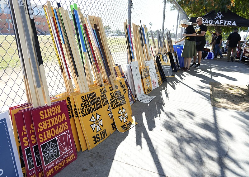Striking SAG-AFTRA members pick out signs for a picket line outside Netflix studios, Wednesday in Los Angeles.
(AP/Chris Pizzello)