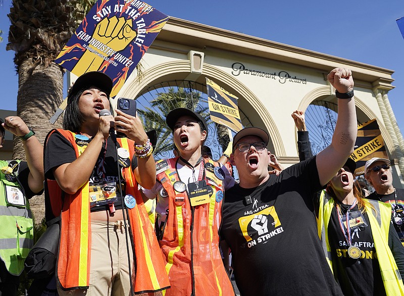 From left, SAG-AFTRA captains Iris Liu and Miki Yamashita and SAG-AFTRA chief negotiator Duncan Crabtree-Ireland lead a cheer for striking actors outside Paramount Pictures studio, Friday, Nov. 3, 2023, in Los Angeles. (AP Photo/Chris Pizzello)