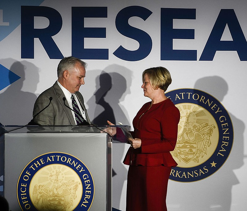 Arkansas Attorney General Tim Griffin (left) shakes hands with Arkansas Children’s CEO Marcy Doderer during a news conference Thursday at Arkansas Children’s Research Institute in Little Rock to announce a planned $70 million research center focused on opioids’ impact on children.
(Arkansas Democrat-Gazette/Stephen Swofford)