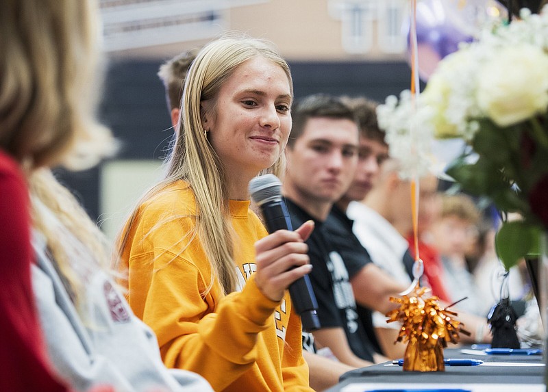 Bentonville’s Haley Loewe takes a microphone as she prepares to speak Thursday after signing a national letter of intent to run cross country at the University of Tennessee during a ceremony at Tiger Arena in Bentonville.
(NWA Democrat-Gazette/Charlie Kaijo)