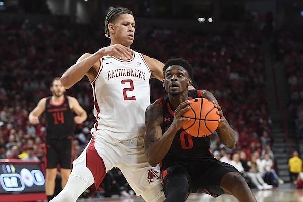 Arkansas forward Trevon Brazile (2) reaches to defend Friday, Nov. 10, 2023, as Gardner-Webb guard Caleb Robinson attempts to enter the lane during the first half of play in Bud Walton Arena.