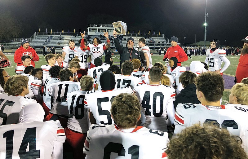 Jefferson City coach Damon Wells holds up the district plaque after Jays' 37-34 win Friday night in the Class 4 District 5 championship game at Pleasant Hill. (Trevor Hahn/News Tribune)