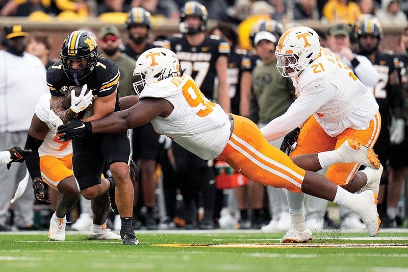 Missouri running back Cody Schrader runs with the ball as Tennessee defensive linemen Omari Thomas (center) and Kurott Garland defend during Saturday’s game at Faurot Field in Columbia. (Associated Press)