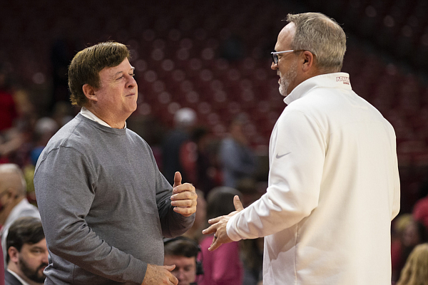 UALR coach Joe Foley and Arkansas coach Mike Neighbors talk before a game Sunday, Dec. 12, 2021, at Bud Walton Arena in Fayetteville. (David Beach/Special to the NWA Democrat-Gazette)