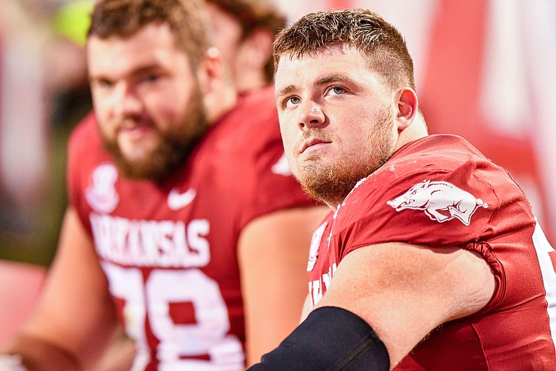 Arkansas offensive linemen Brady Latham (right) and Joshua Braun (78) react on the sideline, Saturday, Nov. 11, 2023, during the fourth quarter of the Razorbacks’ 48-10 loss to the Auburn Tigers at Donald W. Reynolds Razorback Stadium in Fayetteville.