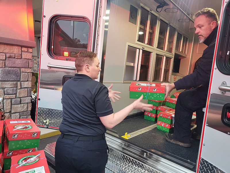Emergency medical providers unload Operation Christmas Child shoeboxes from a ProMed ambulance on Wednesday at Immanuel Baptist Church. (Caitlan Butler/News-Times)