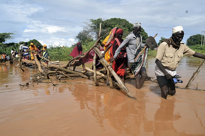 Residents of Chamwana Muma village walk through floodwaters after using a makeshift bridge to cross the swollen River Tana in Tana Delta, Kenya, on Wednesday.
(AP/Gideon Maundu)