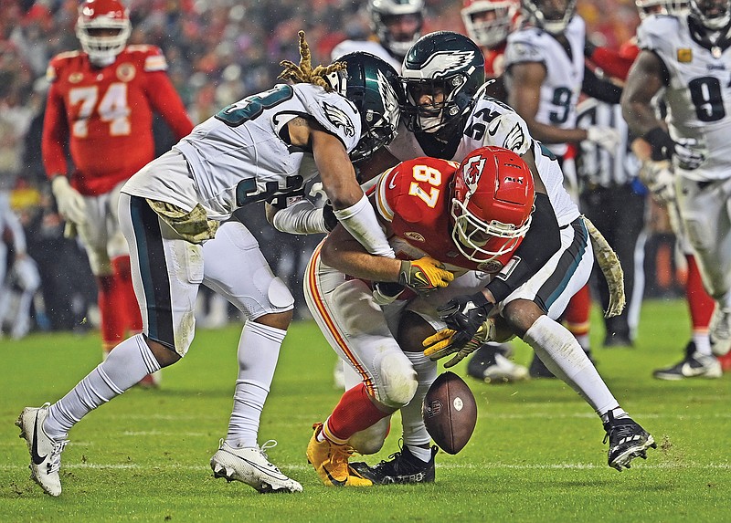 Chiefs tight end Travis Kelce fumbles the ball after getting hit by Eagles cornerback Bradley Roby (33) and linebacker Zach Cunningham (52) during the second half of Monday night’s game at Arrowhead Stadium in Kansas City. (Associated Press)