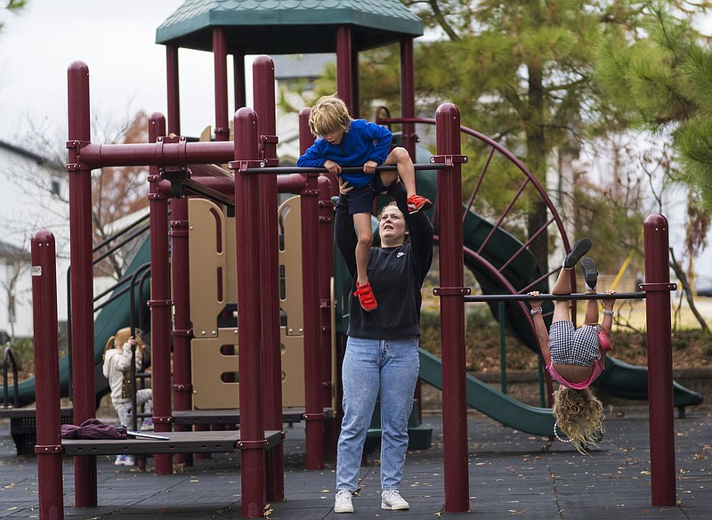 Anika Hingerl of Bentonville helps Oliver Sanders, 6, up a jungle gym, Thursday, November 16, 2023 at Gilmore Park in Bentonville. The Bentonville City Council on Tuesday approved a $257,795 donation for park improvements. “We really like it because it’s near from our home,” said Anika Hingerl, an au pair to twins, adding that she takes them to the Gilmore Park almost every day. “They have swings, they have slides, and it’s just to get the energy out of the kids.” Visit nwaonline.com/photos for today's photo gallery...(NWA Democrat-Gazette/Charlie Kaijo)