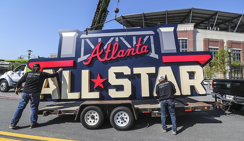 FILE - Workers load an All-Star sign onto a trailer after it was removed from Truist Park in Atlanta, Tuesday, April 6, 2021. Major League Baseball will play its 2025 All-Star Game in Atlanta, four years after moving the game from Truist Park to Denver’s Coors Field over objections to changes in Georgia’s votings rights laws. Baseball Commissioner Rob Manfred made the announcement Thursday, Nov. 16, 2023, following an owners’ meeting. (John Spink/Atlanta Journal-Constitution via AP, File)