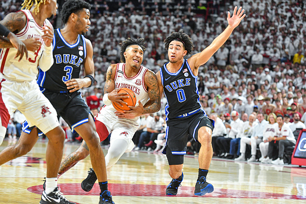 Arkansas guard Jeremiah Davenport (24) drives as Duke guard Jared McCain (0) defends, Wednesday, Nov. 29, 2023, during the first half of the Razorbacks’ game against the Blue Devils at Bud Walton Arena in Fayetteville.